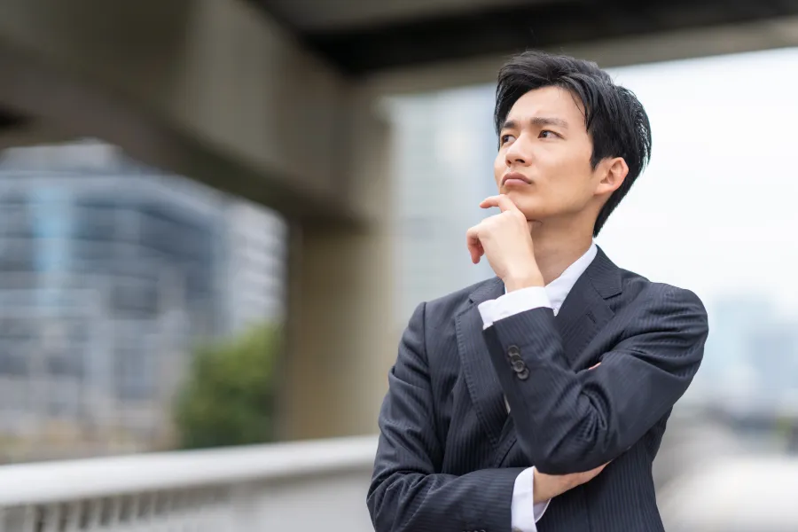 考えごとをするビジネスパーソン。うまく説明できるか不安な方に配慮するイメージ