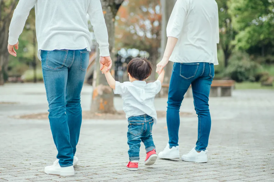 両親と子どもが手をつなぐ様子。親権・監護の取り決めをイメージした写真